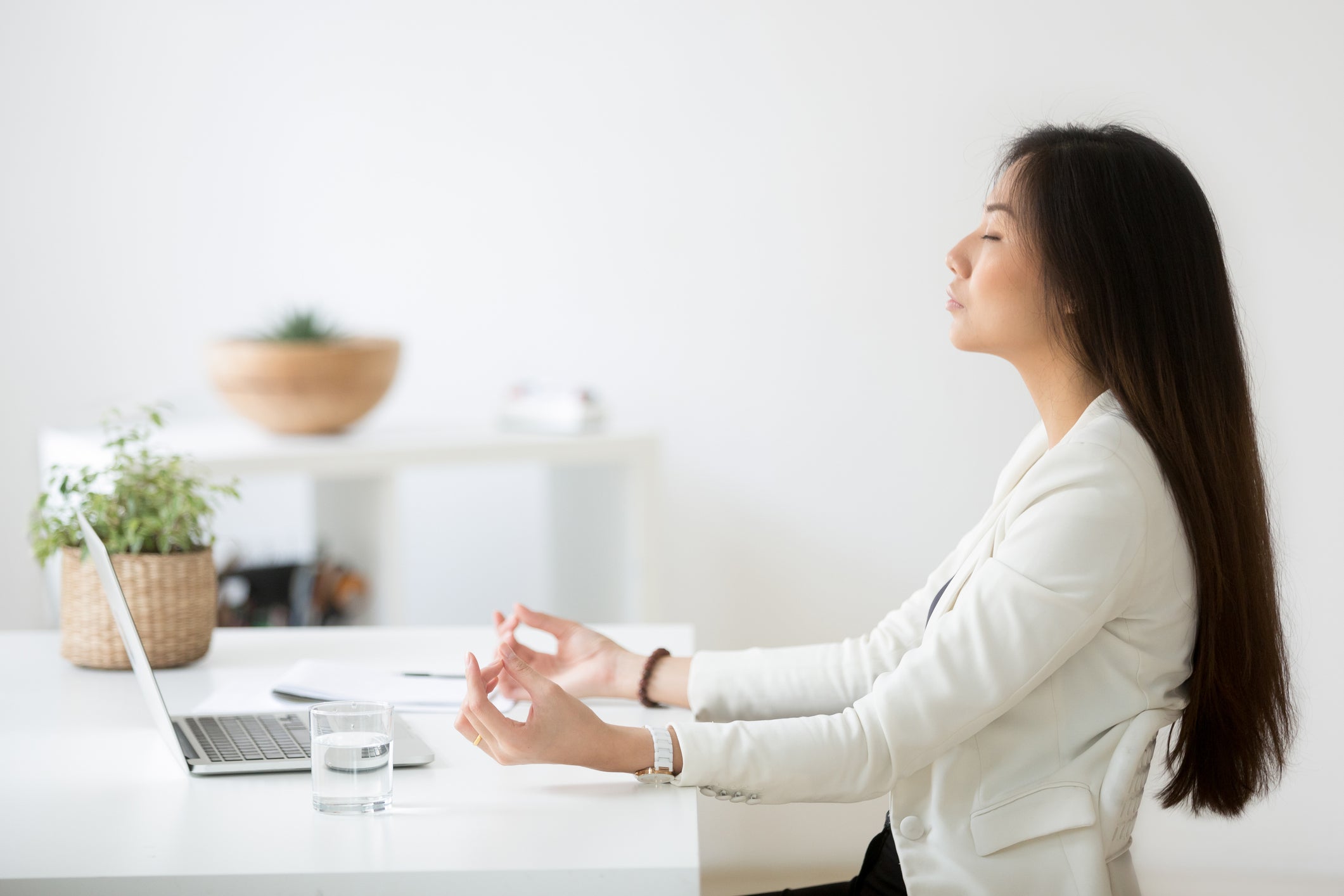 woman meditating at her laptop