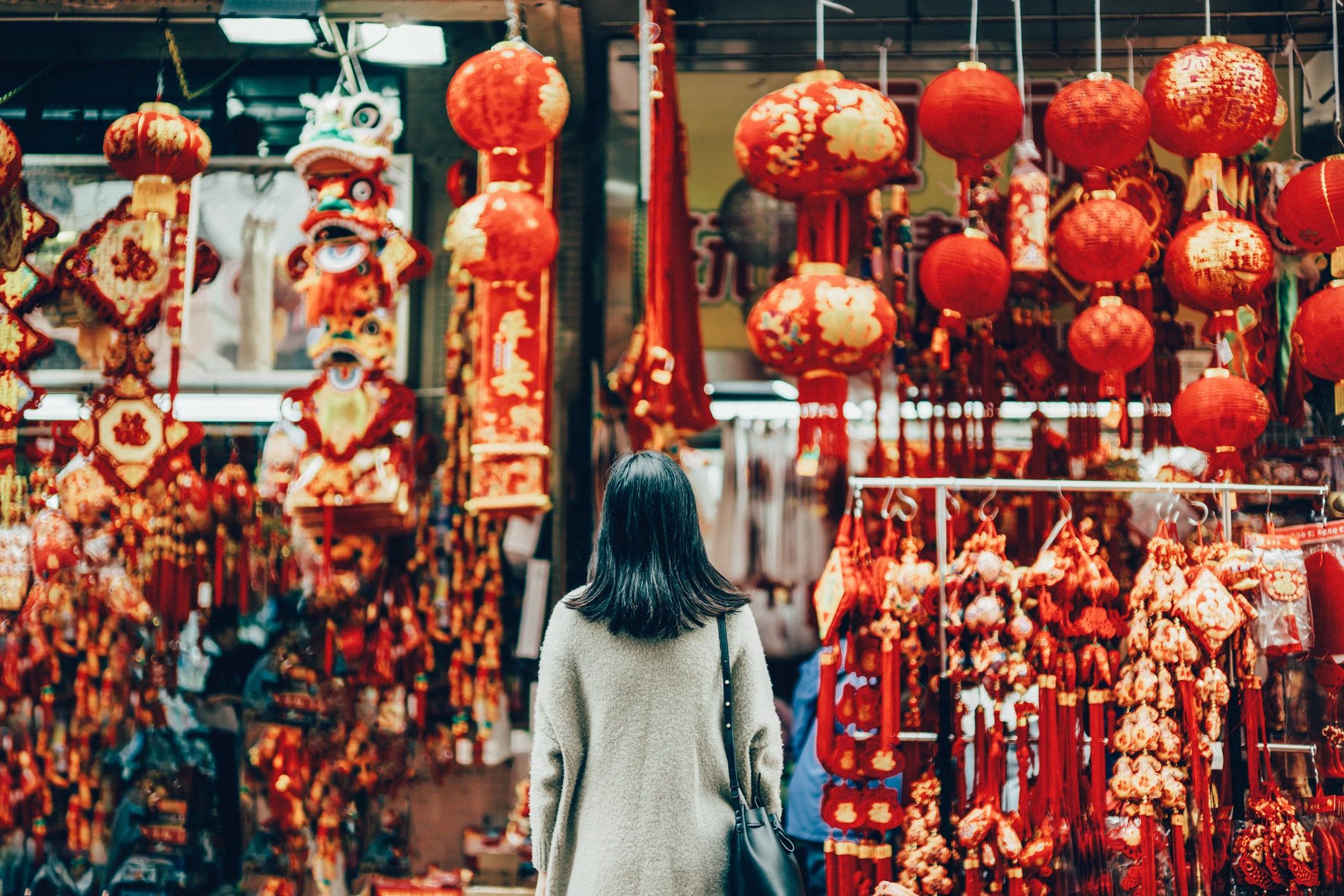 a woman in Chinatown looking at Chinese decorations to illustrate a story about asian vegetarians