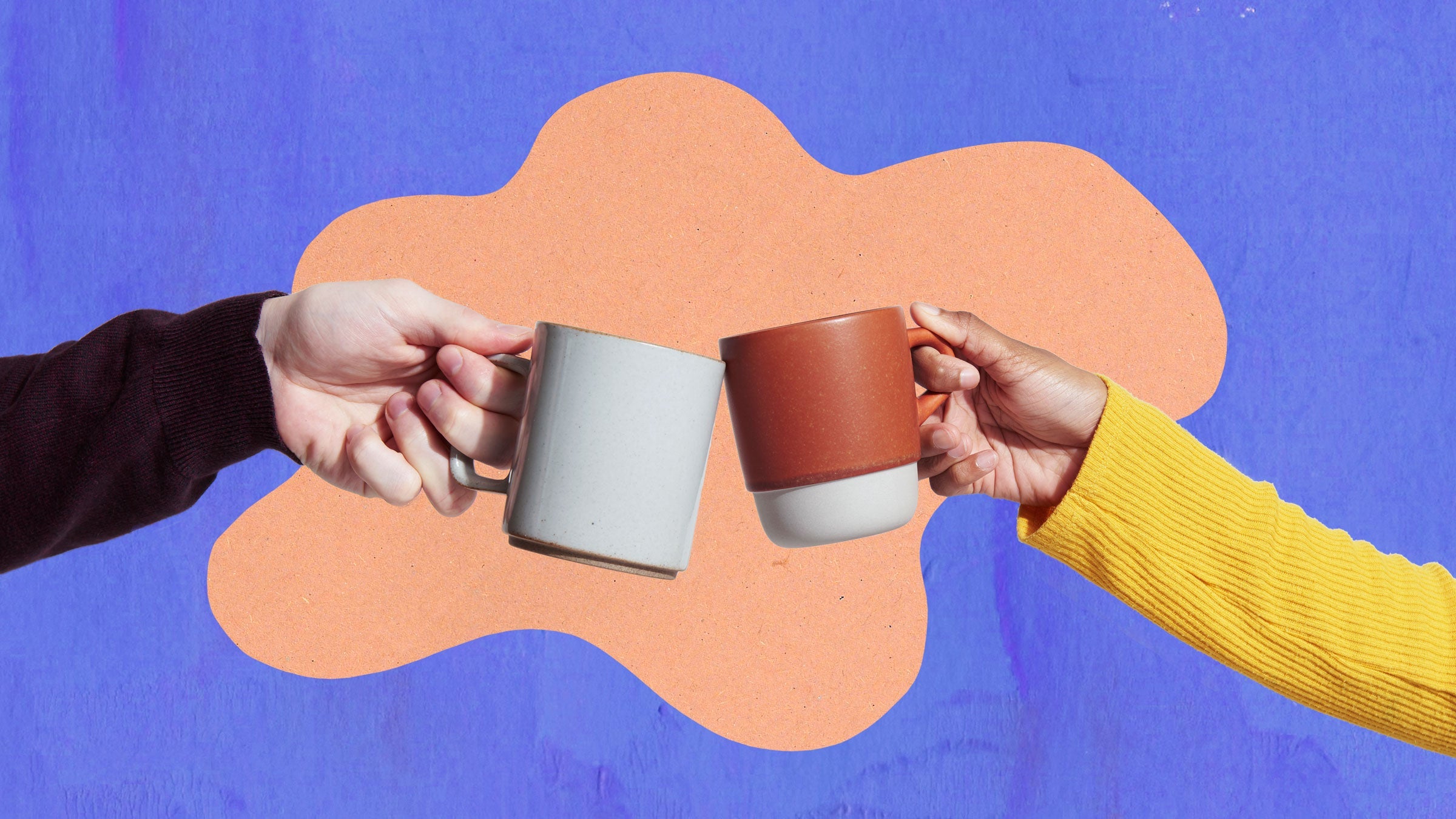Two coffee mugs clink together